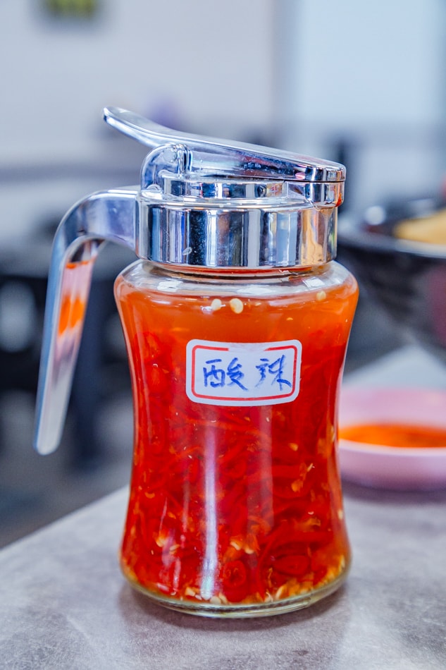 酸辣醬料特寫：小碟裝調味料準備加入船麵中提味