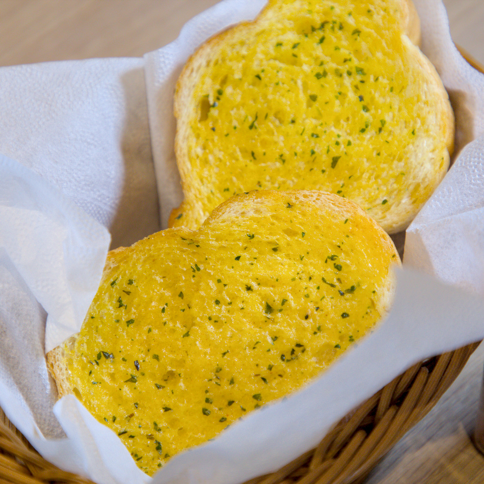 蒜香麵包特寫 外酥內軟撒上香草與奶油醬