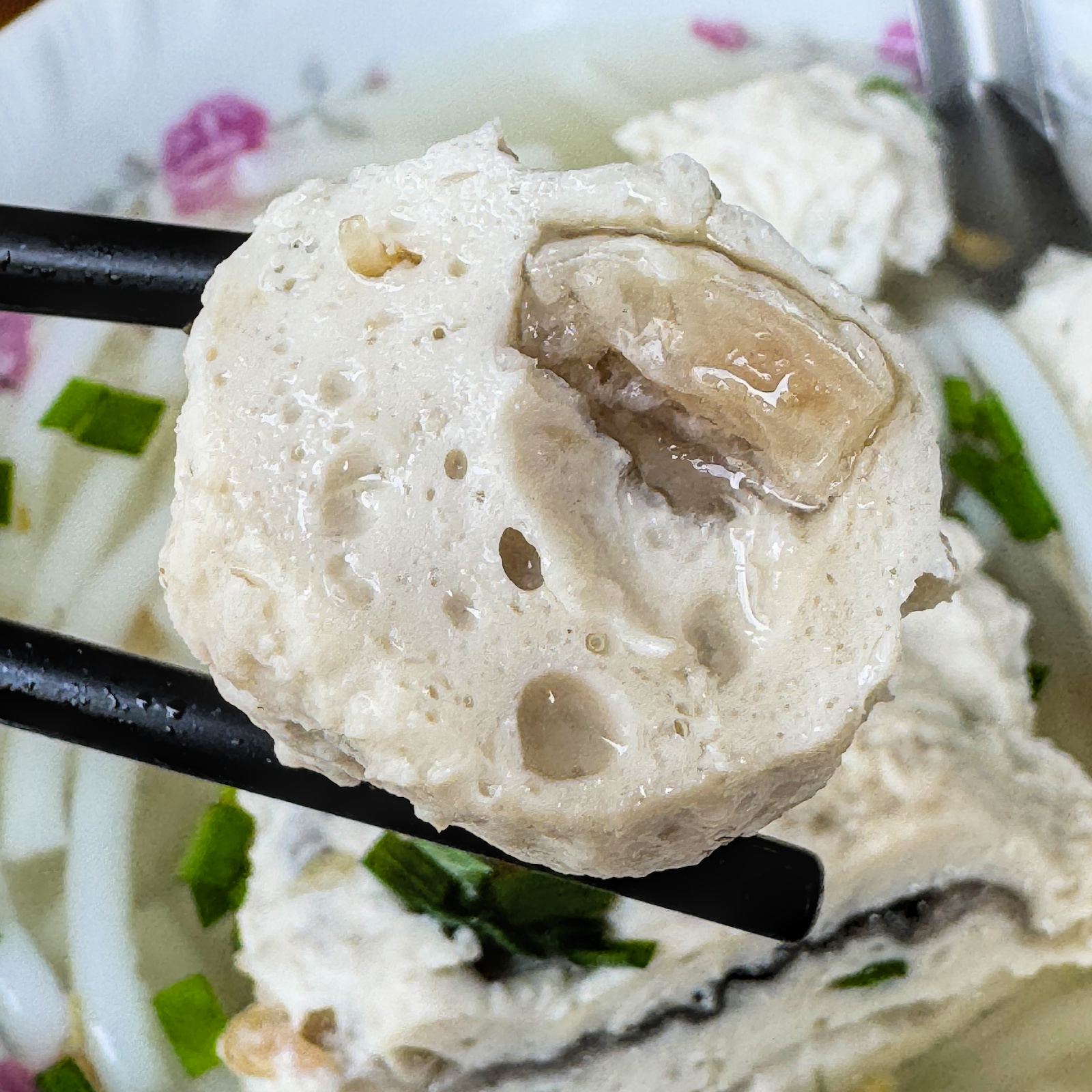 圓球狀的虱目魚丸特寫，濃郁集中，代表傳統高雄虱目魚風味，為綜合米粉湯的經典元素。