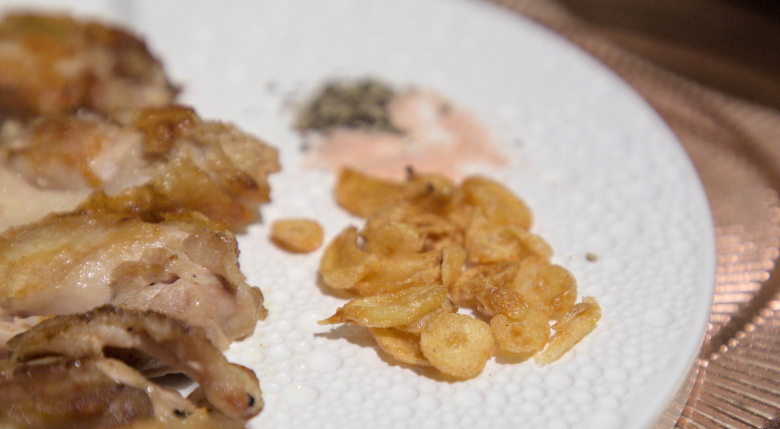 牛排切塊特寫，搭配師傅手炒香蒜片，風味更上一層樓