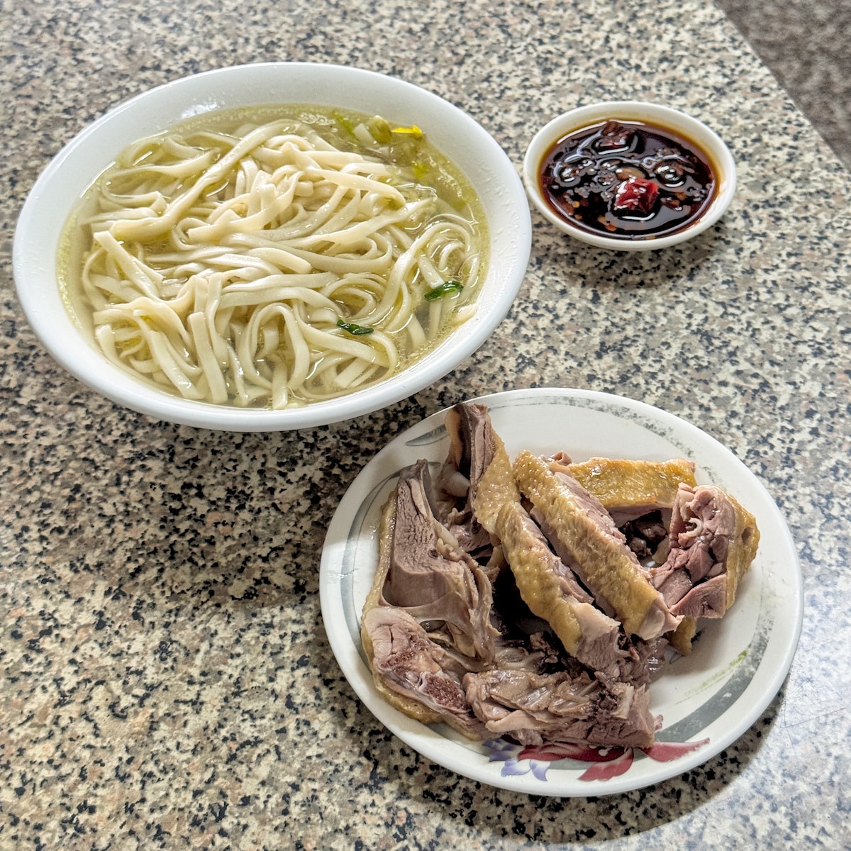 岡山第一鴨肉冬粉熱門餐點特寫：清湯麵與鮮嫩鴨肉切盤，沾上特製辣醬油後滋味更升級
