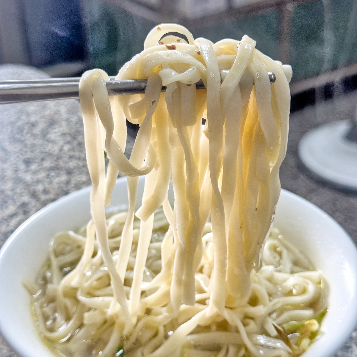 清湯麵條細節特寫：口感Ｑ彈不軟爛的寬麵，完美吸附鴨骨湯頭精華