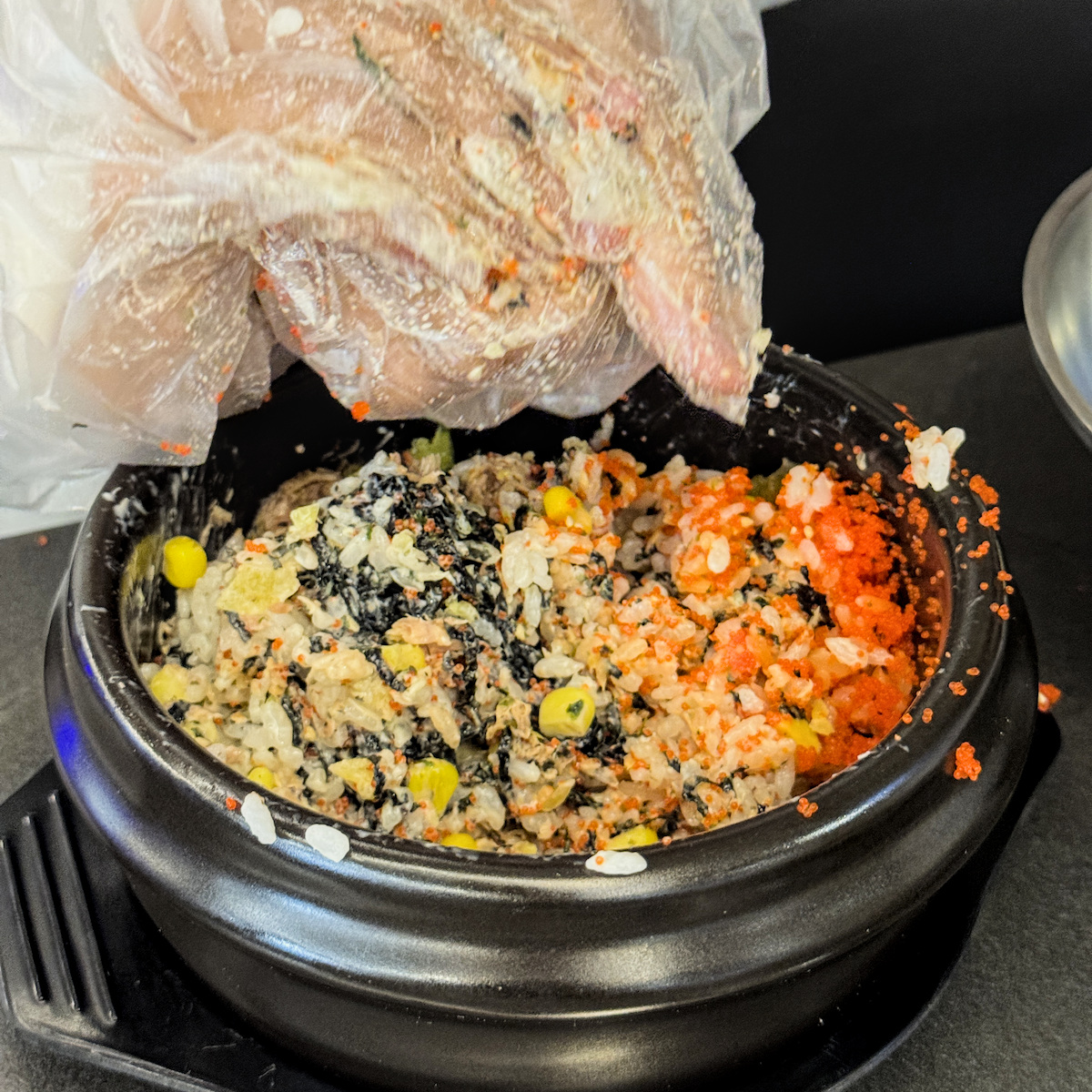 戴上手套手捏拌飯的樂趣，將魚子與配料均勻揉捏成拳頭飯團