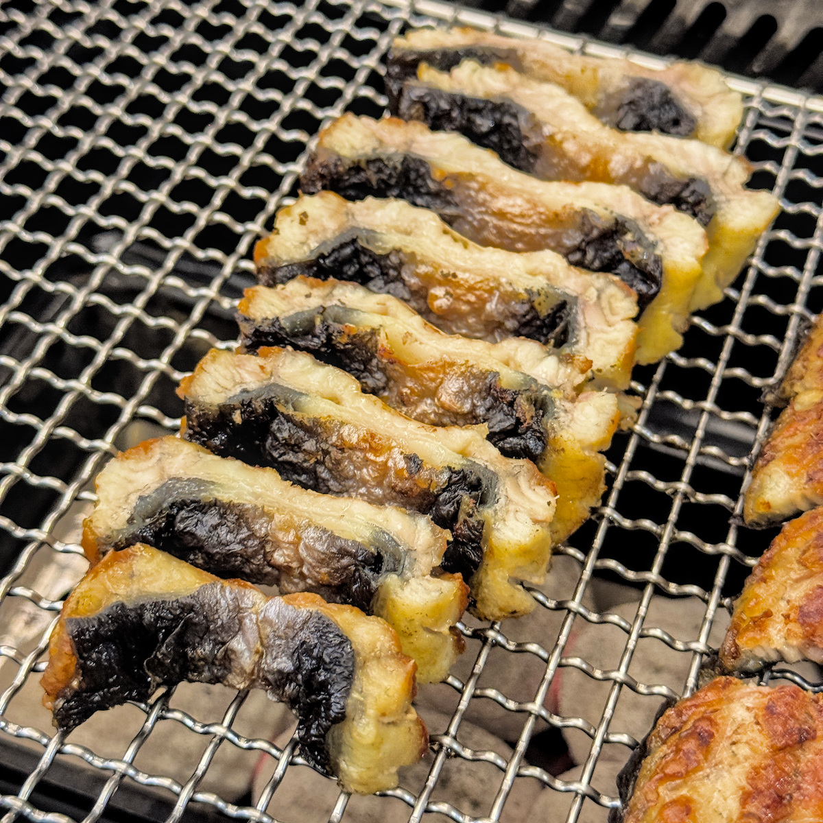 烤鰻魚搭配韓式吃法所需的新鮮配料，包含紫蘇葉、生菜與特製醬汁