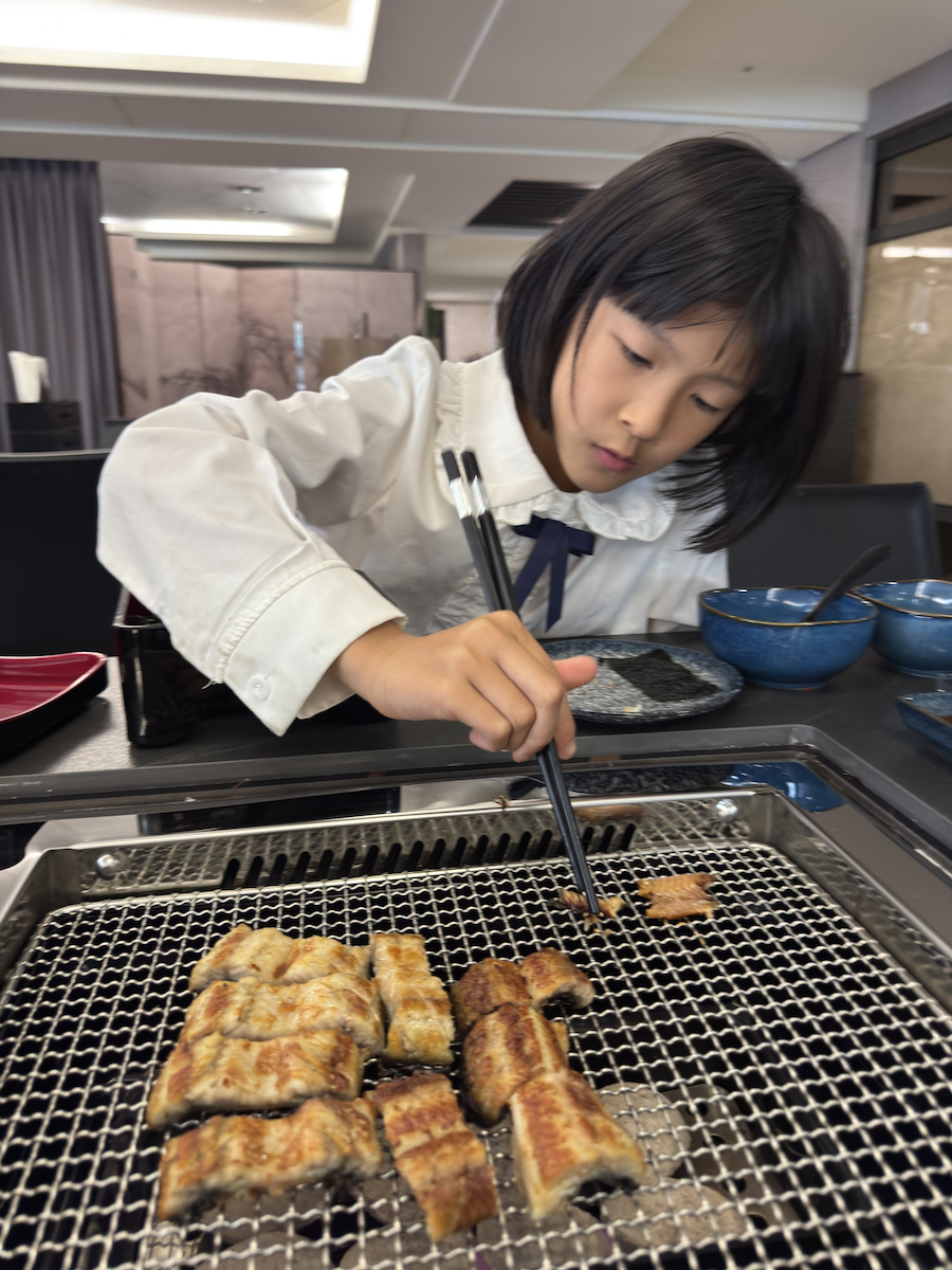 特寫一口大小的烤鰻魚，外皮如餅乾般酥脆，魚肉質地飽滿Q彈