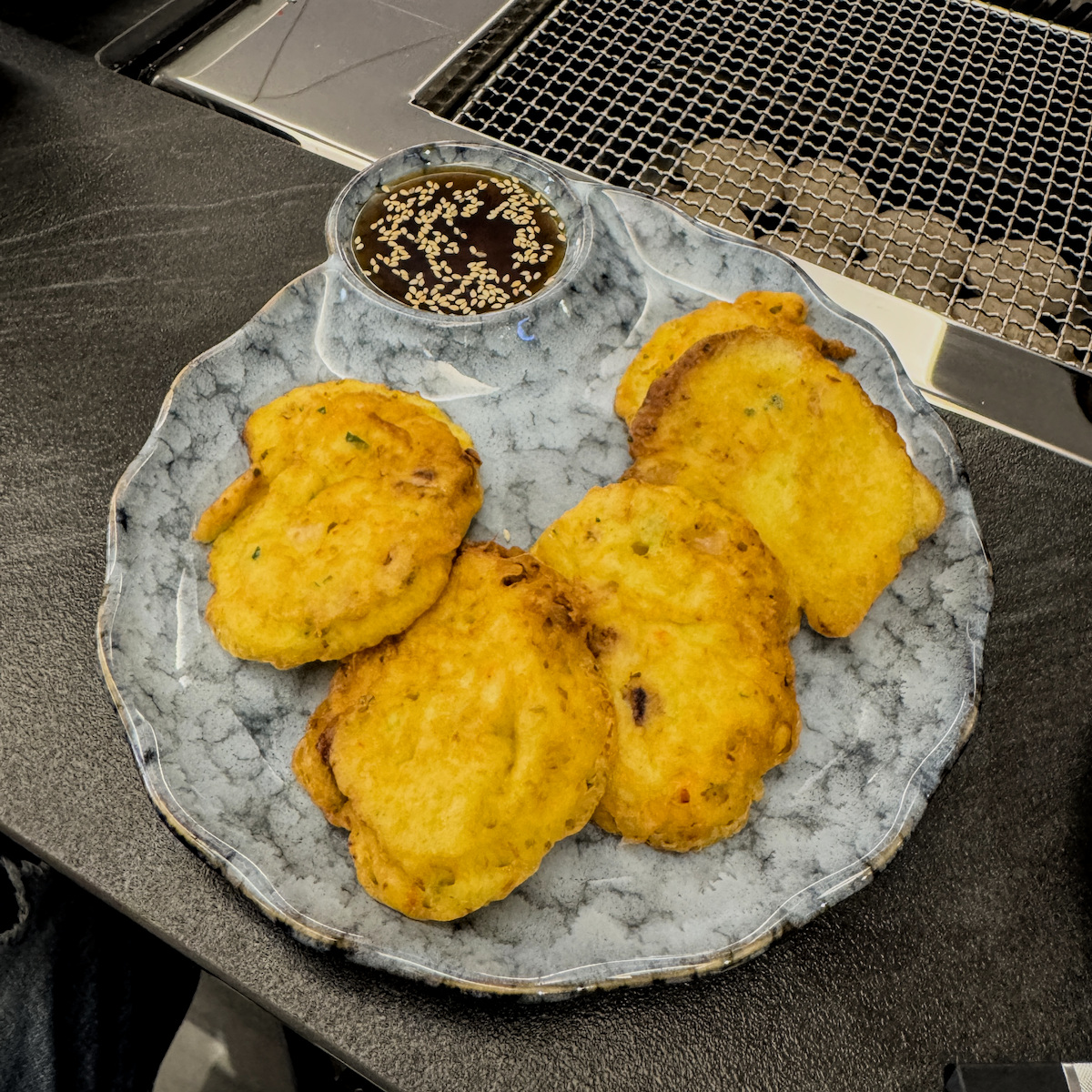 海鮮小煎餅，邊緣金黃酥脆，內含鮮甜蝦仁與多樣海鮮配料