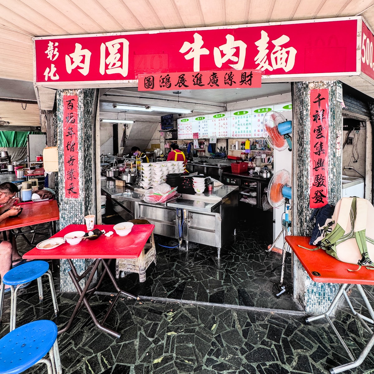 廣招英溫州餛飩大王樸實店內環境，展示櫃檯上堆疊如小山的白瓷碗與充滿煙火氣的現點現做廚房