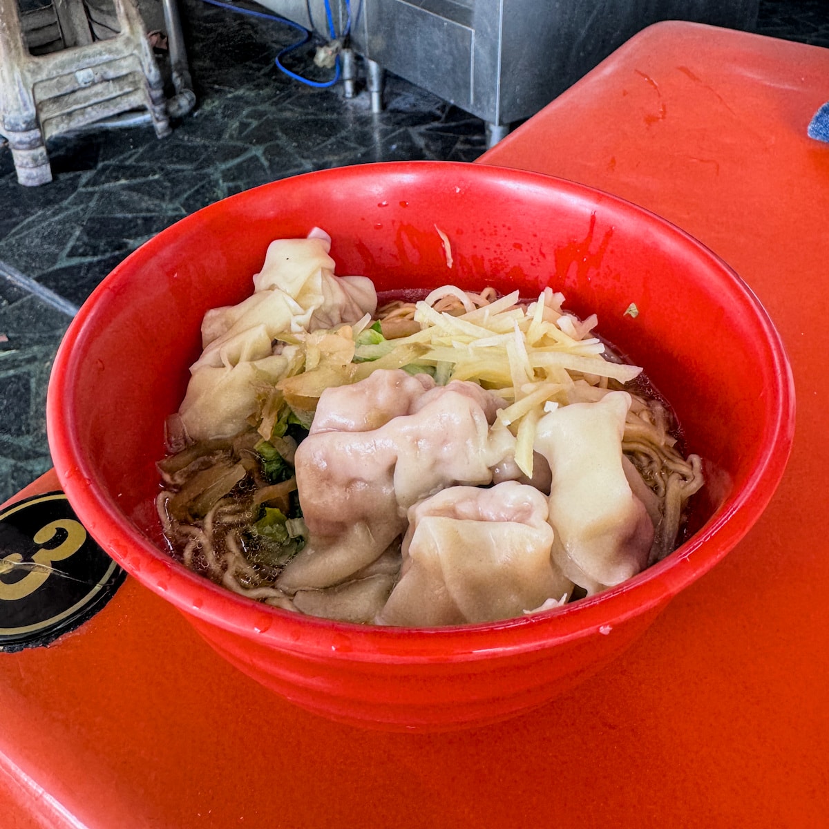 廣招英招牌溫州餛飩乾麵特寫，大顆飽滿的餛飩鋪在Ｑ彈麵條上，份量感十足
