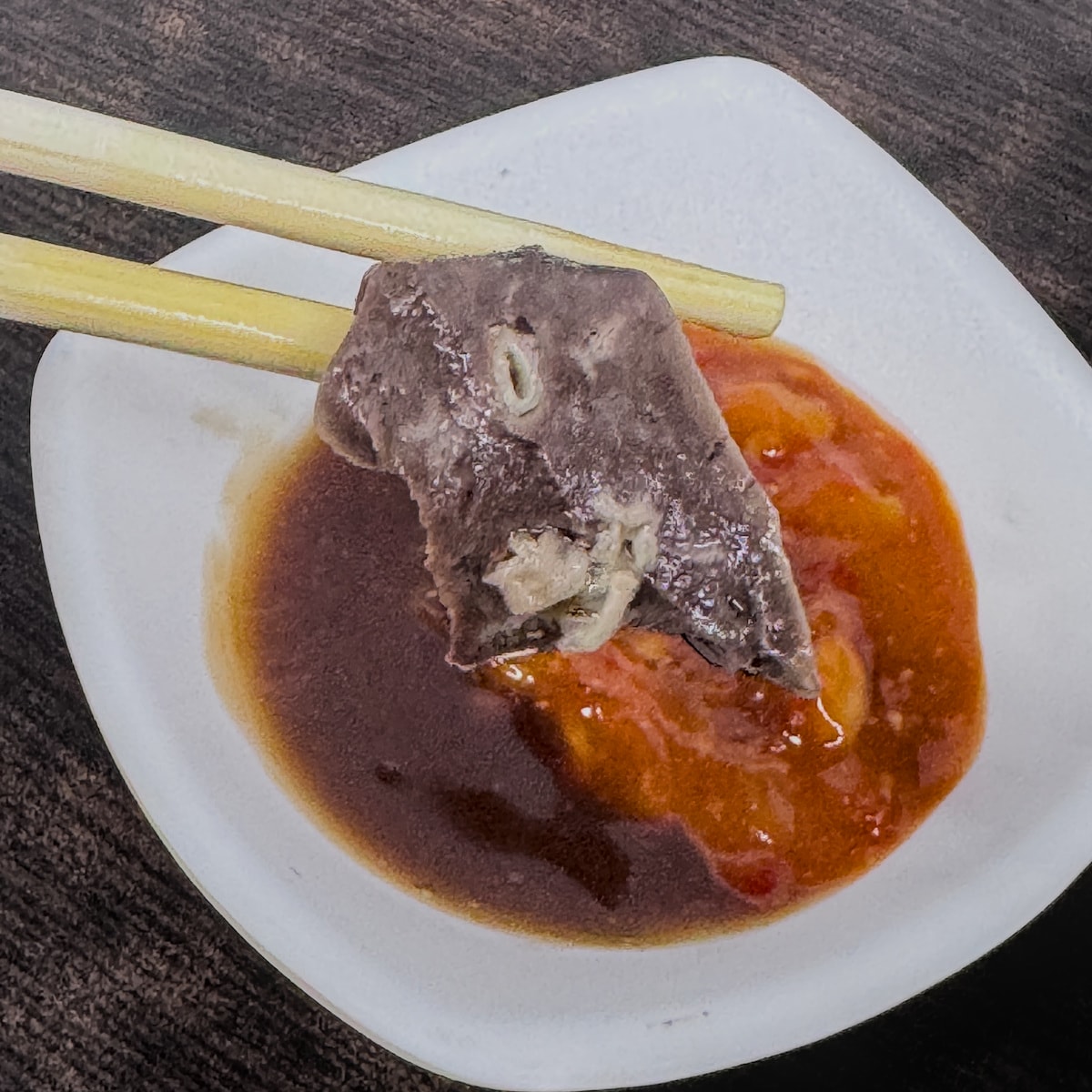將鮮嫩羊肉片沾取豆瓣醬的瞬間，展現岡山道地吃法的美味感