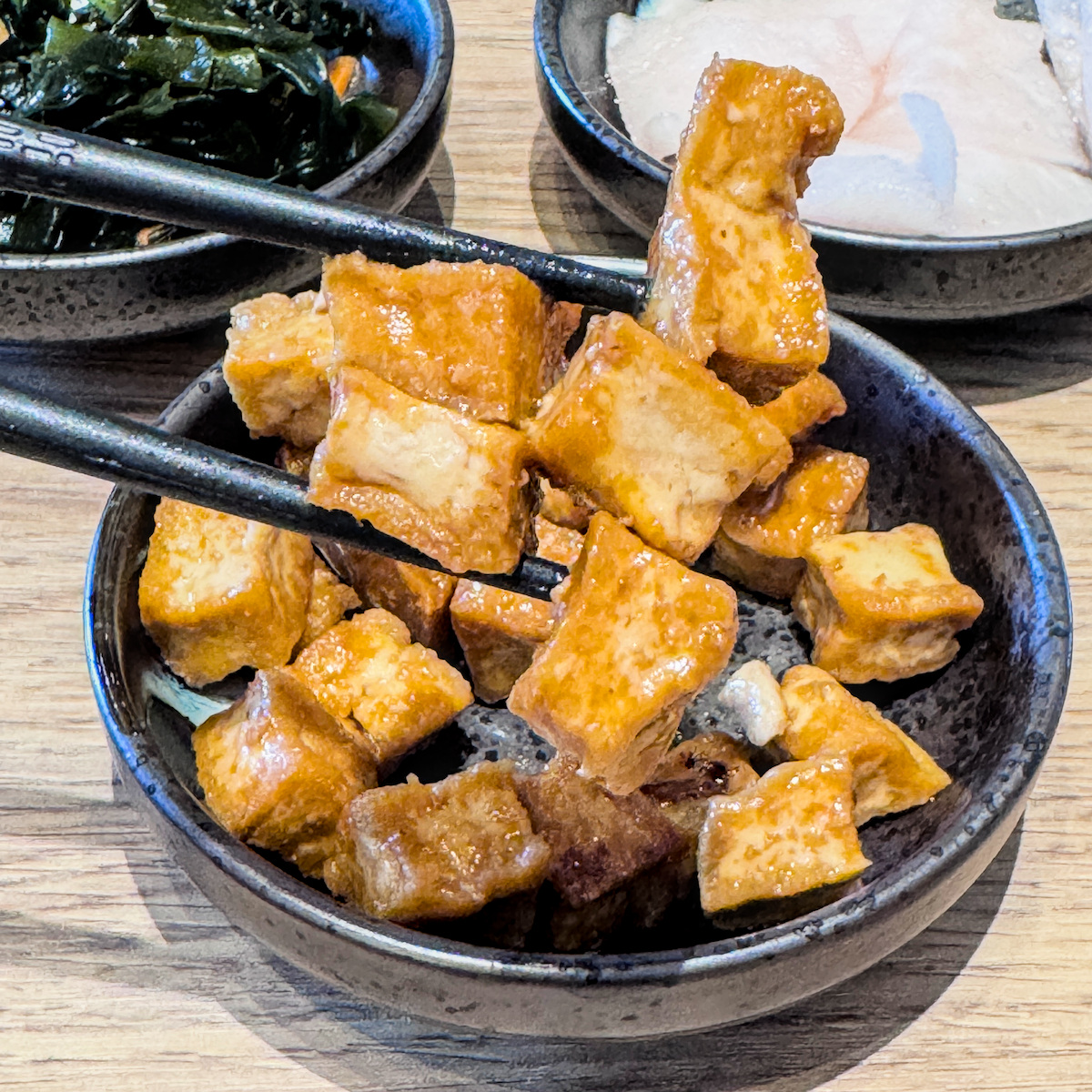 最具飽足感的樂麵屋免費供應小菜：照燒豆腐丁，豆腐外層帶有微微焦香與甜鹹醬汁
