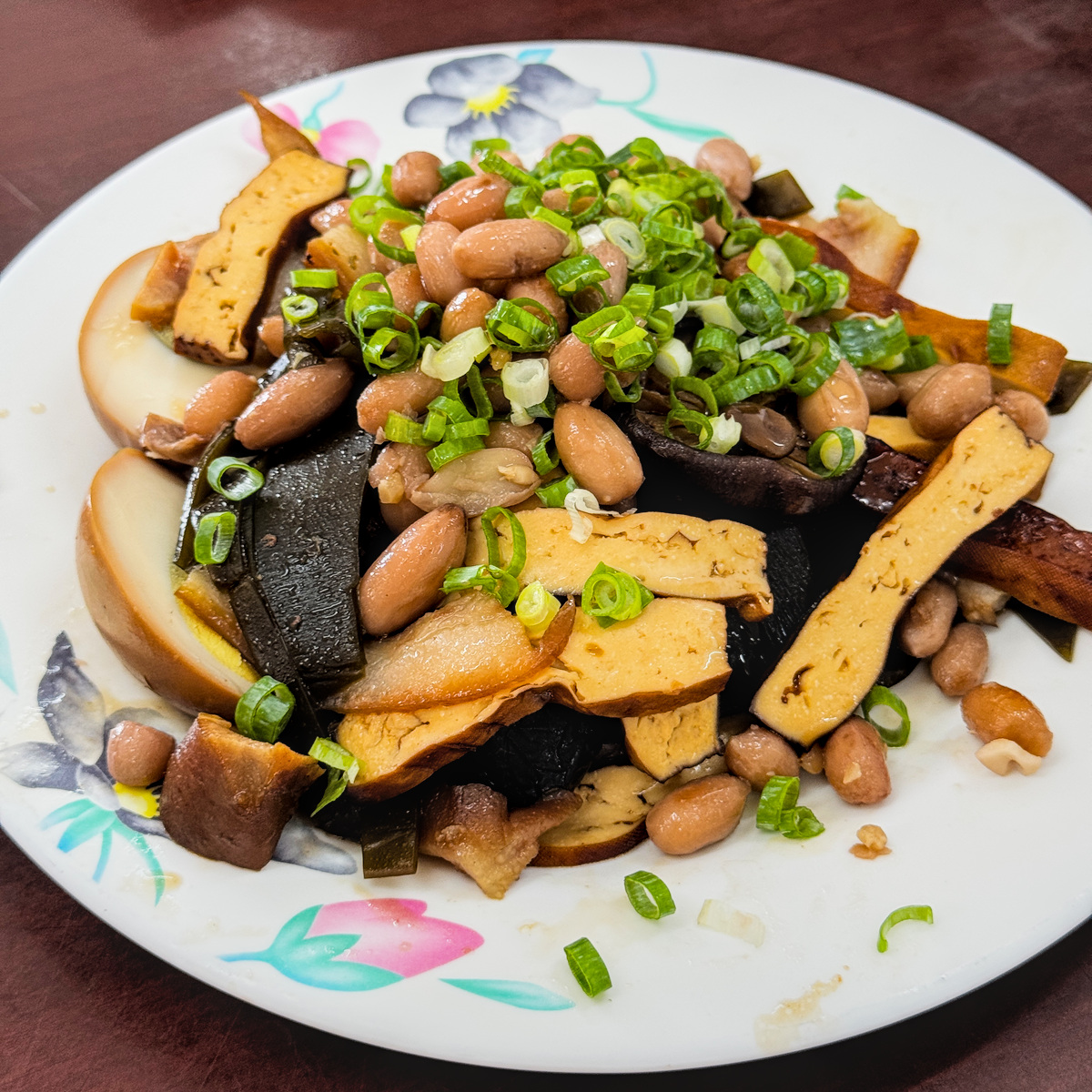 老楊牛肉麵大盤招牌滷味，包含吸滿醬汁的香菇、花生、海帶與豬頭皮
