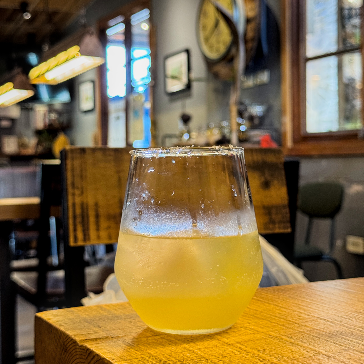 小米酒氣泡飲，糯米酒搭配汽泡水與檸檬汁調製，杯口鹽口設計帶有微醺酸甜風味